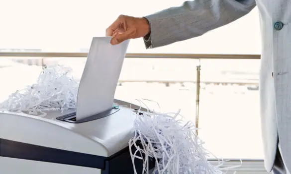 Trituradora de papel funcionando con mano introduciendo hojas