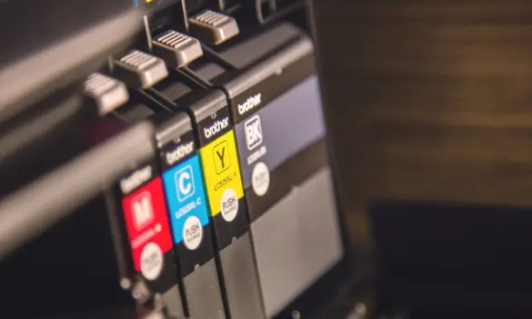 Cartuchos de tinta de impresora ordenados en fila con códigos de color